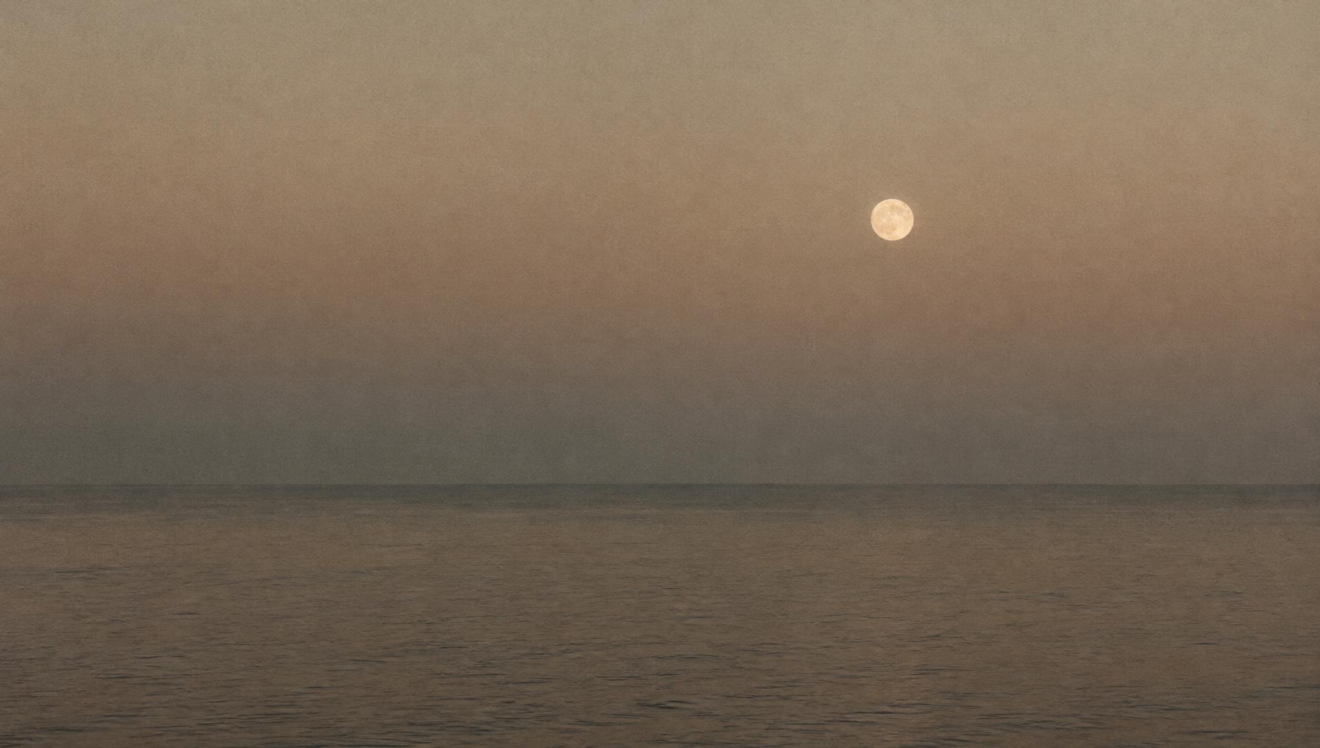 Ruhiger Meereshorizont mit aufgehendem Mond